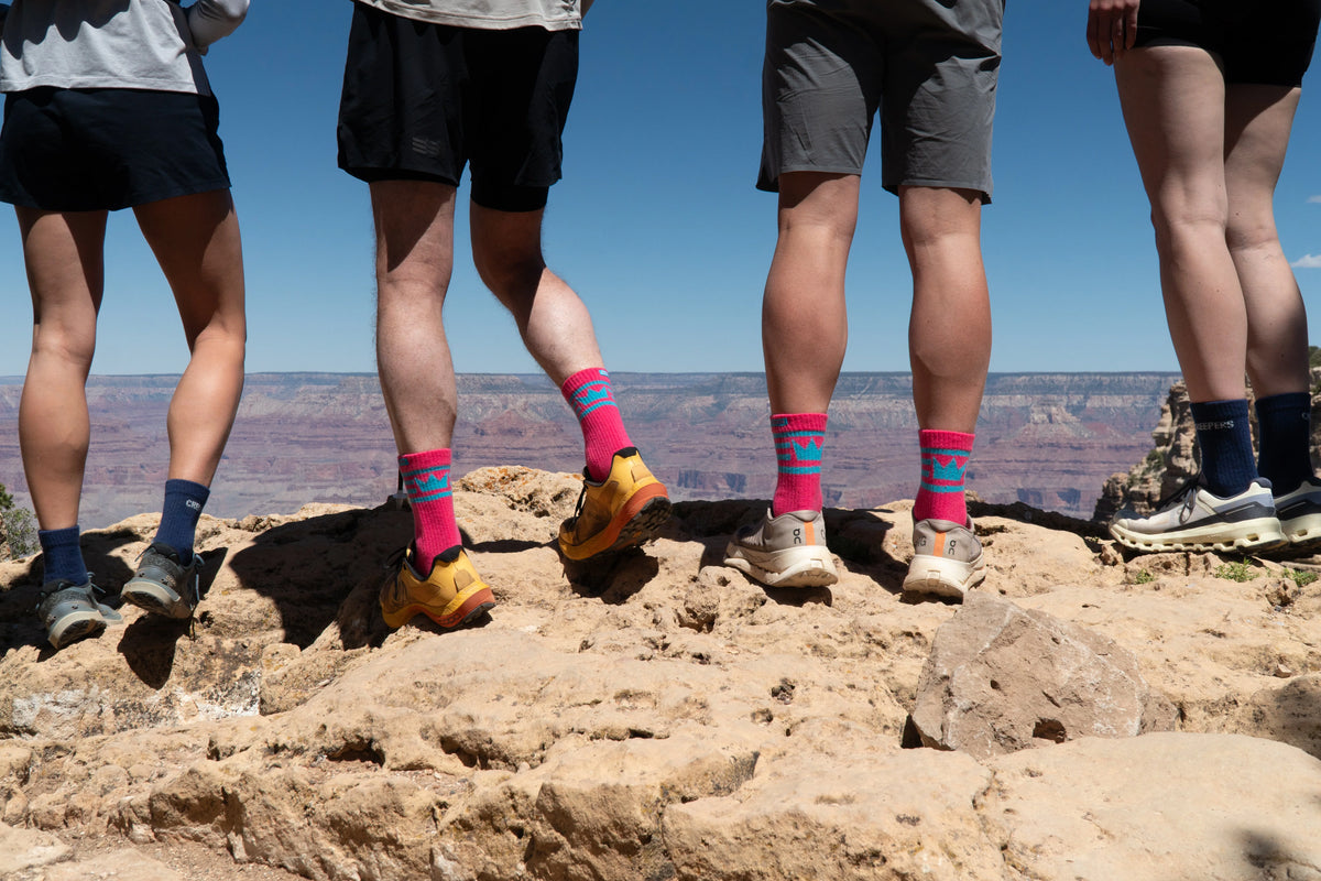 Group of runners wearing Creepers toe socks standing on a rocky summit
