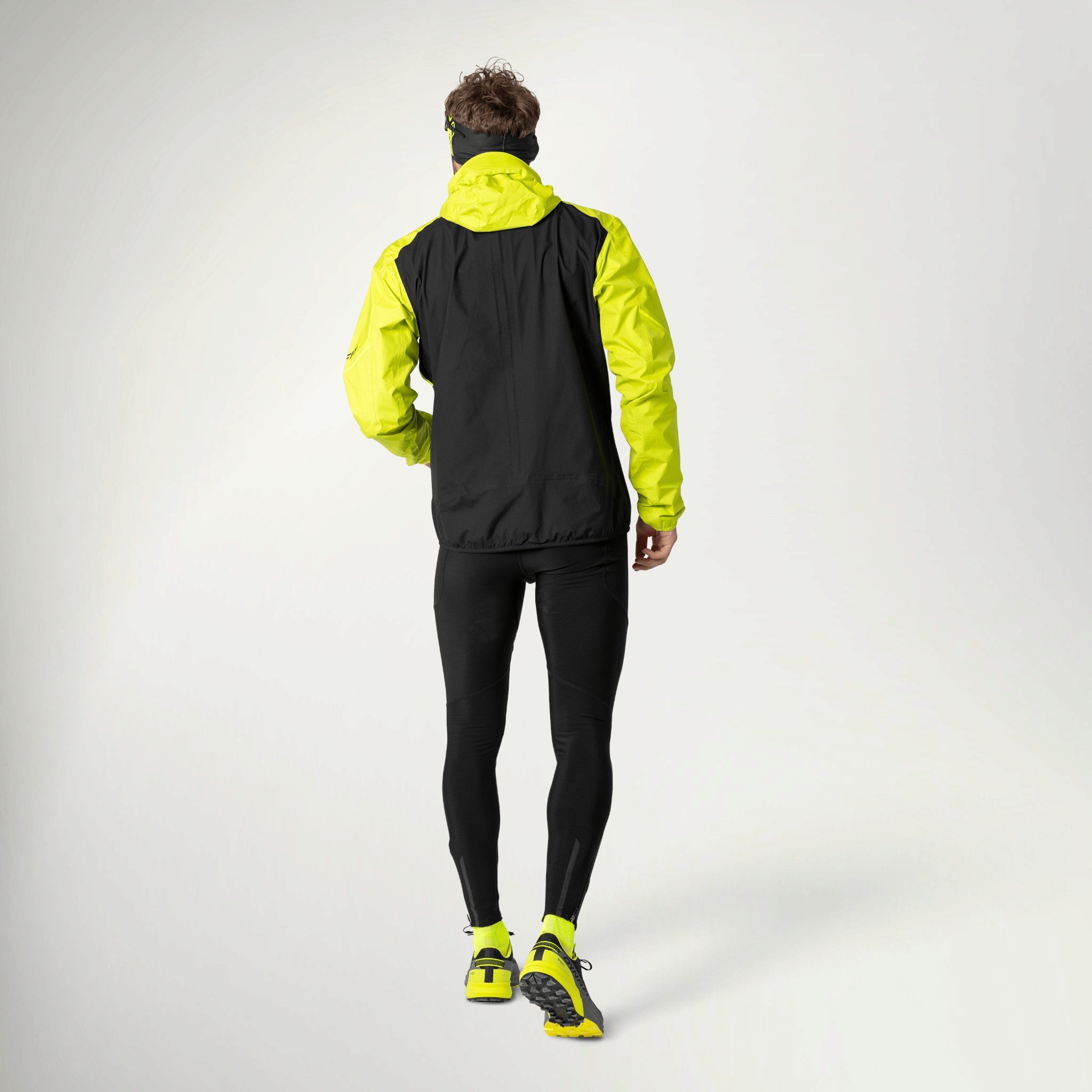Dynafit Alpine 3-Layer Jacket Men's in Ultra Yellow worn by a runner, back view