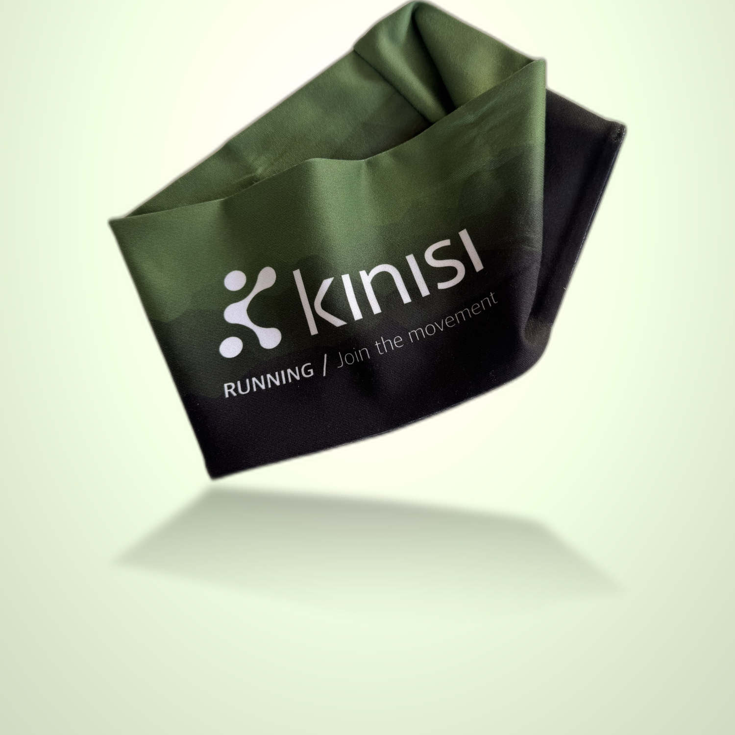 A dark green and black fabric running headband with the Kinisi logo and 'RUNNING / Join the movement' printed on it, shown floating against a pale green gradient background.