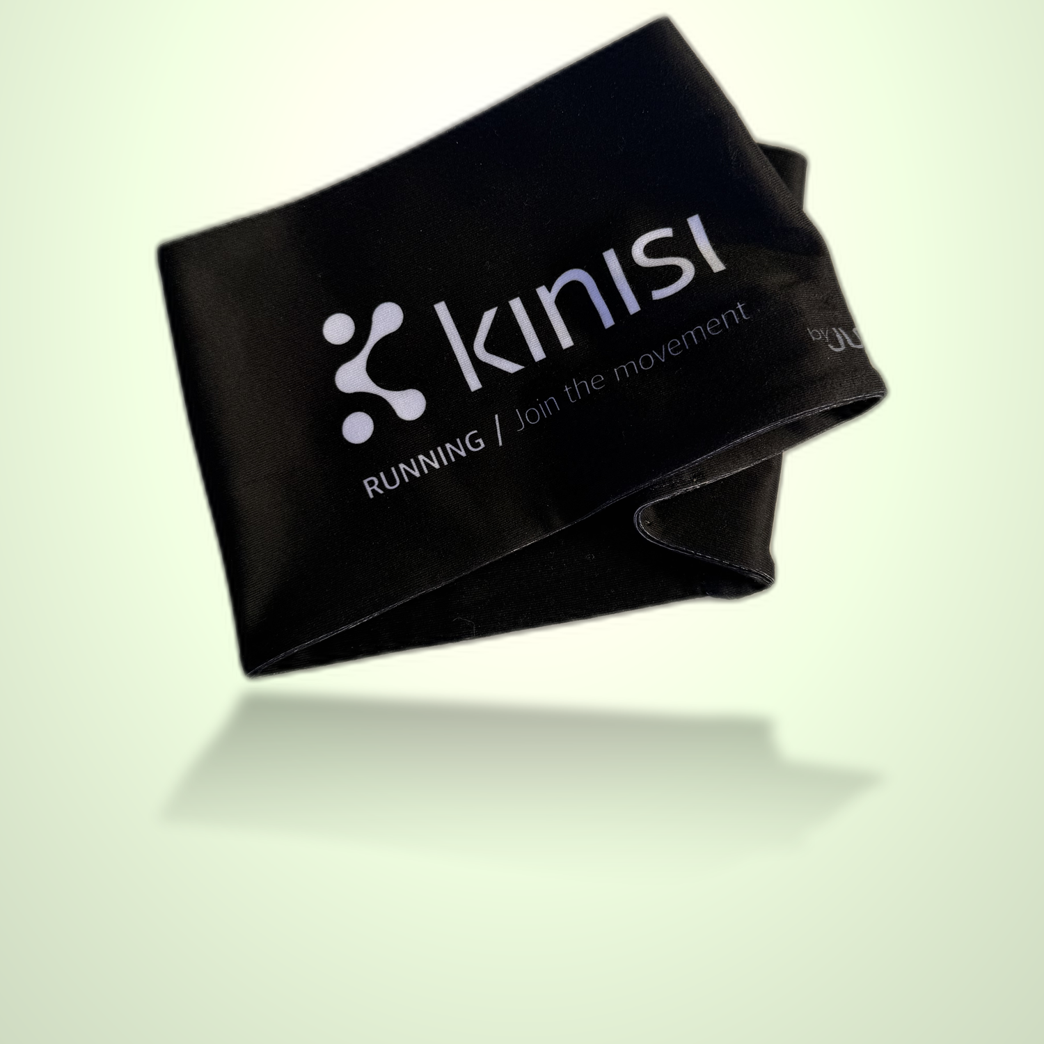 A black fabric running headband with the Kinisi logo and 'RUNNING / join the movement.' printed in white, shown floating against a pale green gradient background.
