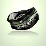 A Kinisi Running brand athletic headband in a black and olive green color scheme, featuring a white stylized logo and graphic mountain print, shown floating against a light green gradient background.