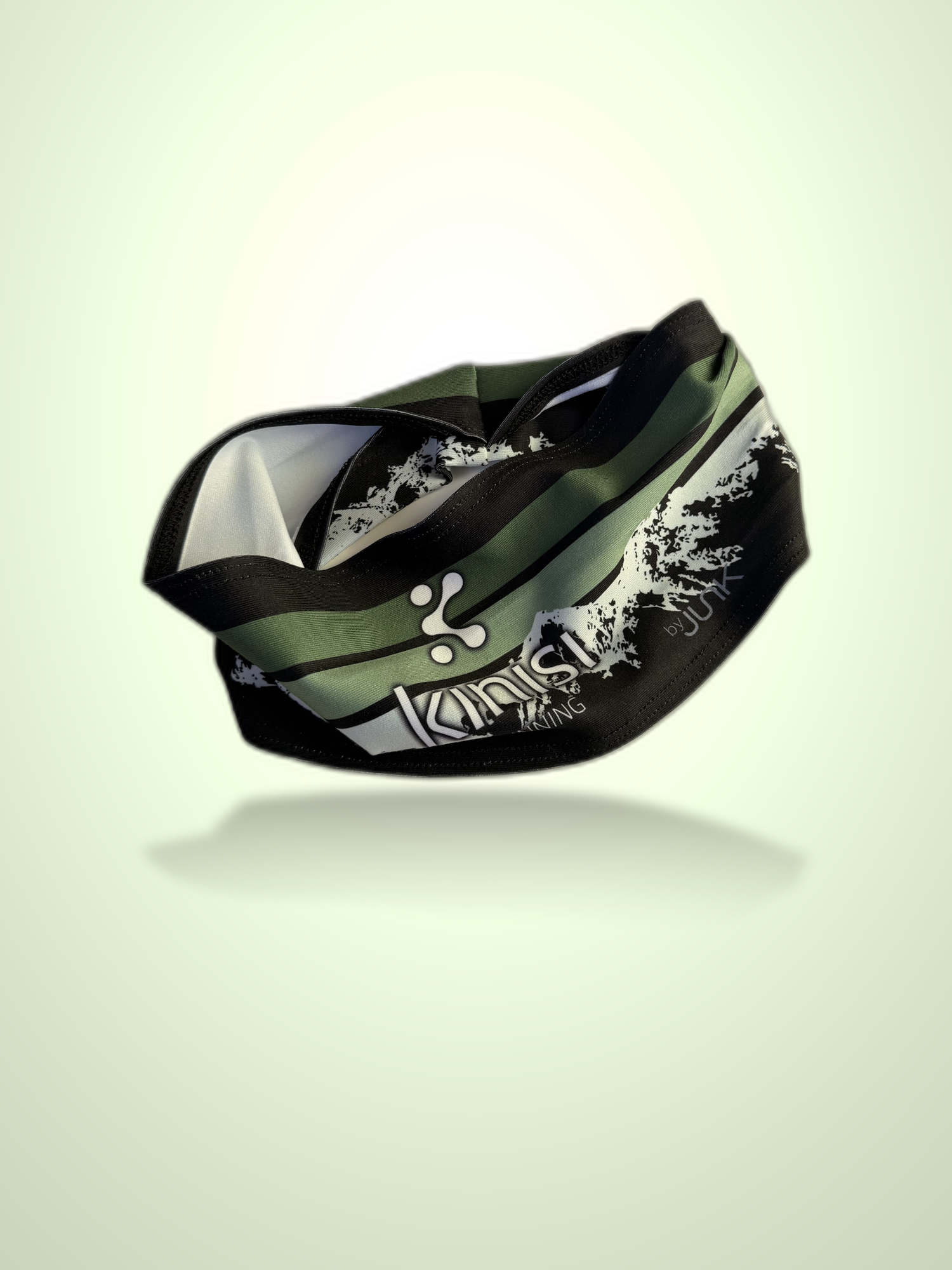 A Kinisi Running brand athletic headband in a black and olive green color scheme, featuring a white stylized logo and graphic mountain print, shown floating against a light green gradient background.