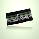 A black athletic headband with green stripes, a white Kinisi Running logo, and a white mountain graphic, floating on a pale green gradient background.