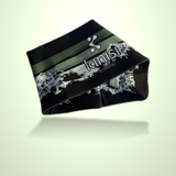 A black athletic headband with green and white graphic stripes and the brand name 'kinisi Running' printed on it, shown floating against a pale green gradient background.