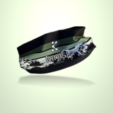 A black running headband with a green stripe and a white mountain graphic, featuring the 'kinisl running' logo, shown floating against a pale green gradient background.
