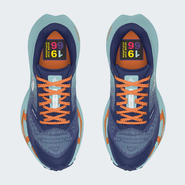 A pair of The North Face running shoes shown from a top-down view on a light gray background. The shoes feature a navy blue mesh upper with bright orange laces, orange accents on the midsole, and a light teal/blue-green outer sole.