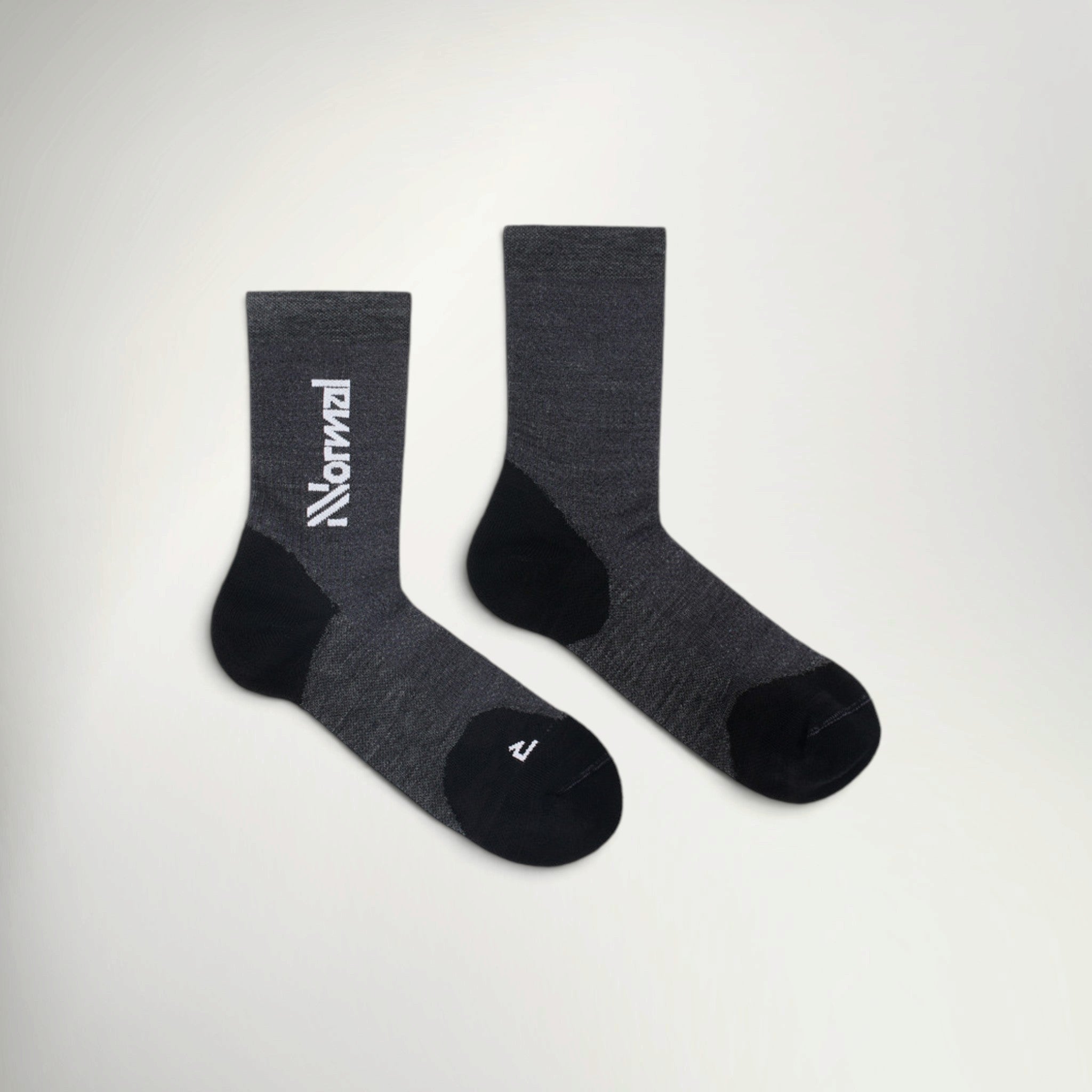 Pair of NNormal Merino Sock 02 crew running socks in Black, charcoal grey with black heel, toe and white NNormal logo