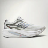 New Balance SuperComp Rebel Women's running shoe in Sea Salt with Neo Flame, side view with white upper, blue N logo and grey midsole