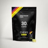 A black stand-up pouch of Precision Fuel 30g carb chews in Mint & Lemon flavor, shown on a light gray background with two green-yellow chew pieces in front.