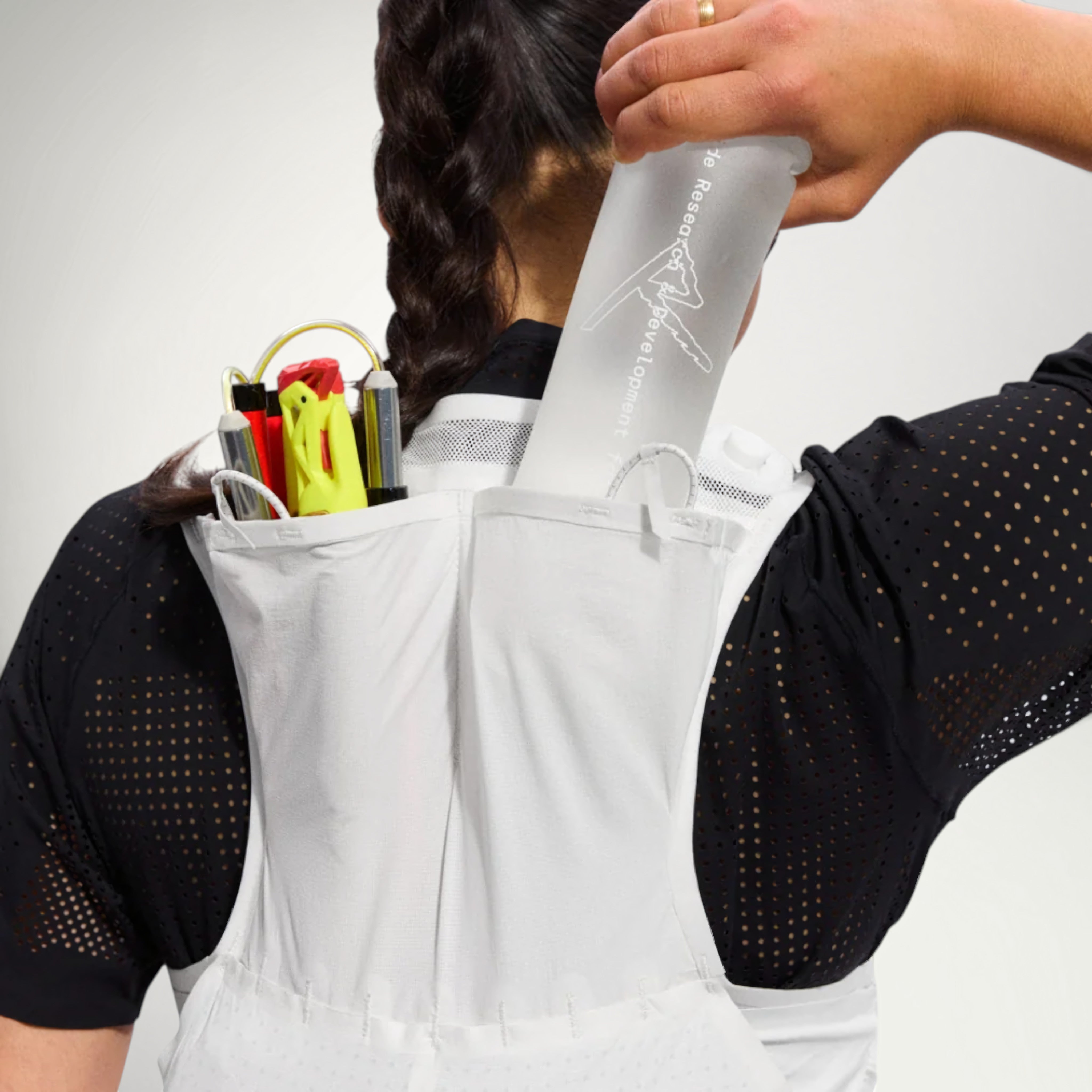Runner loading a soft flask into the Raide LF 5L Running Vest