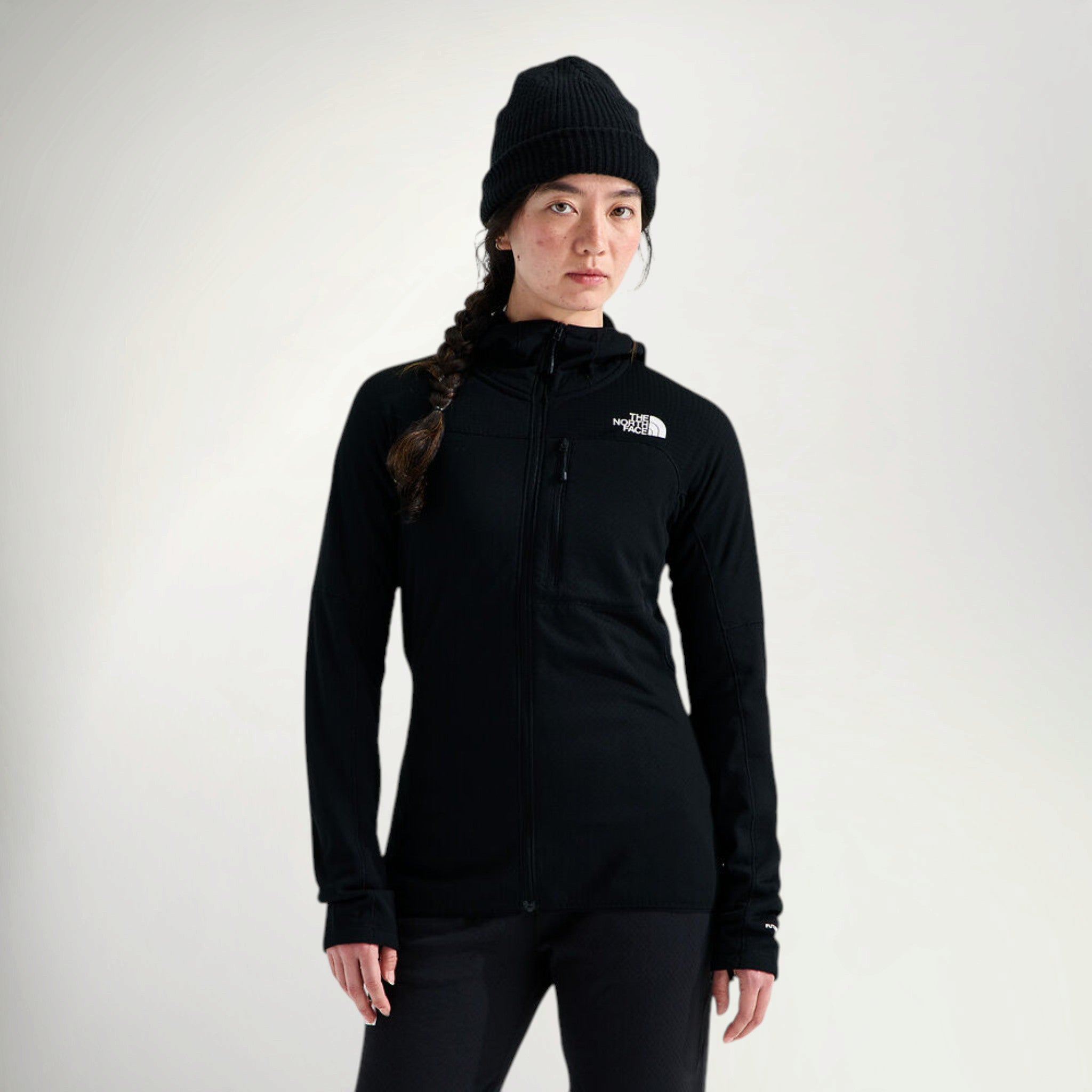 Woman wearing The North Face Women's Summit Series FUTUREFLEECE Full Zip in Black, front view with black beanie