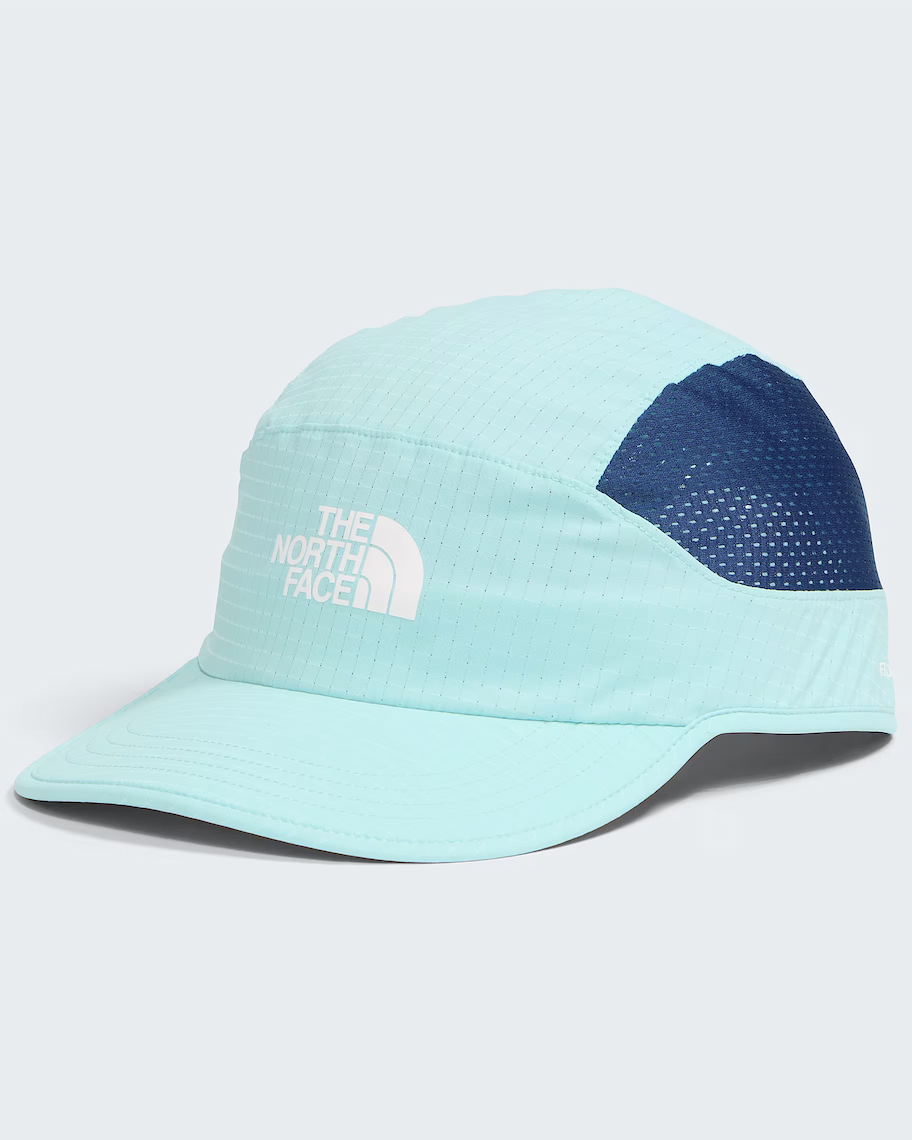 A light blue and navy blue performance cap by The North Face, featuring a white embroidered logo on the front panel, set against a light gray background.