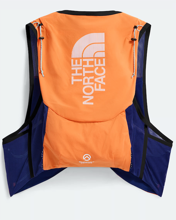 The North Face running vest shown from the back, featuring a bright orange back panel with a large white logo, navy blue mesh side panels, and black trim.