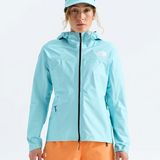 A woman modeling a light blue hooded jacket and matching cap from The North Face, paired with orange shorts, against a clean white studio background.