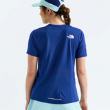 A woman shown from the back wearing a royal blue short-sleeve athletic T-shirt with a small white The North Face logo on the upper back, paired with light mint shorts and a matching two-tone cap, against a clean white studio background.