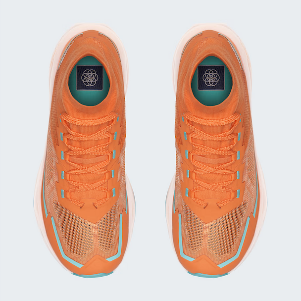 A pair of TNF orange athletic sneakers shown from a top-down view on a light gray background. The shoes feature a textured knit upper, matching orange laces, and light blue accents along the sides and around the eyelets.