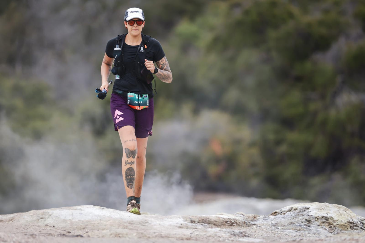 Paula from the Kinisi Running crew racing along a rocky trail